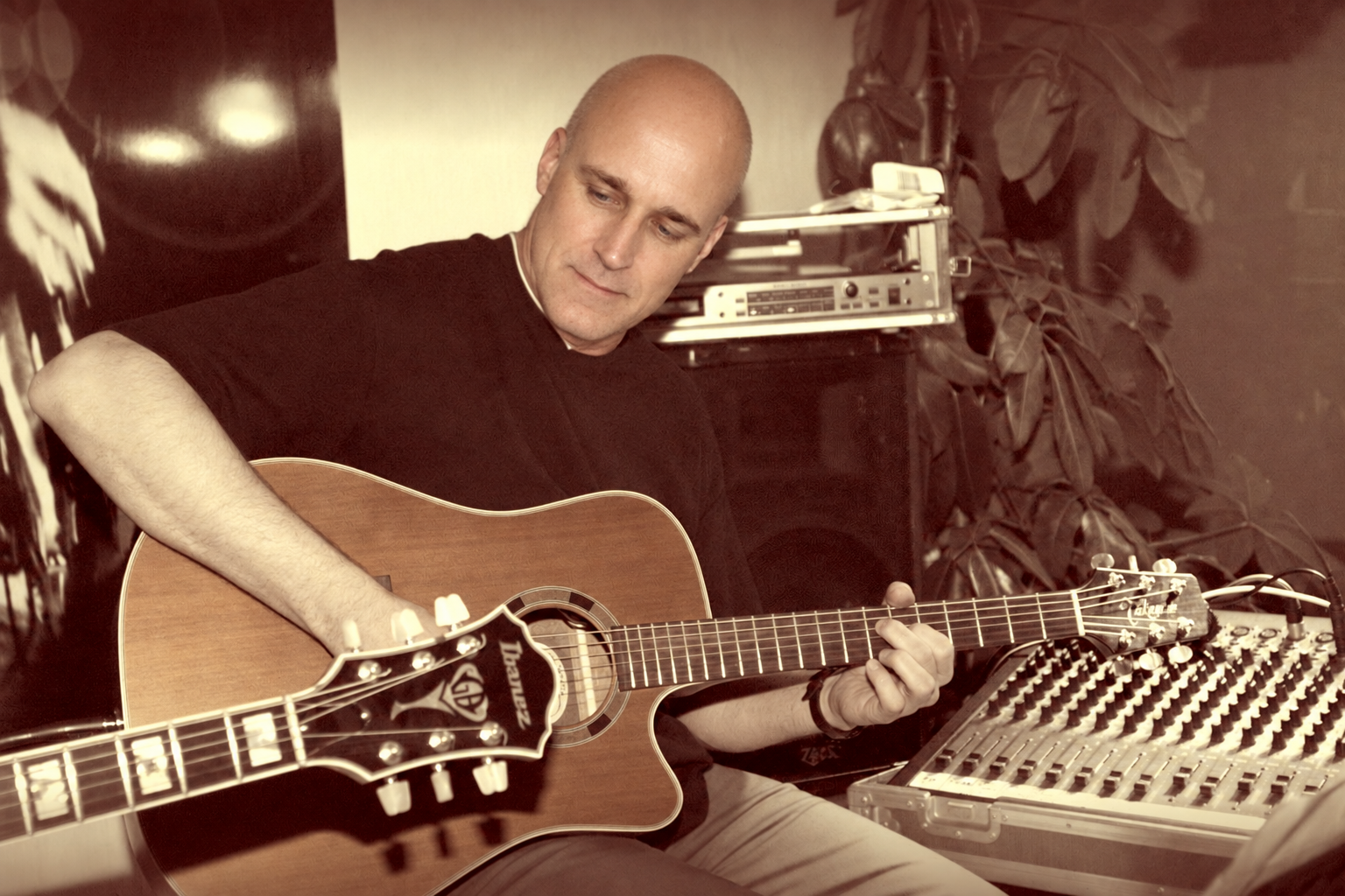 Jens Scheuter mit Takamine neben dem Mischpult – Sepia-Probenfoto